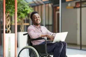 HIGHER EDUCATION PRODUCTS disabled man using laptop