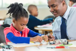 african american student learning about robotics during elementary class