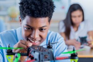 cheerful high school student concentrates while building a drone