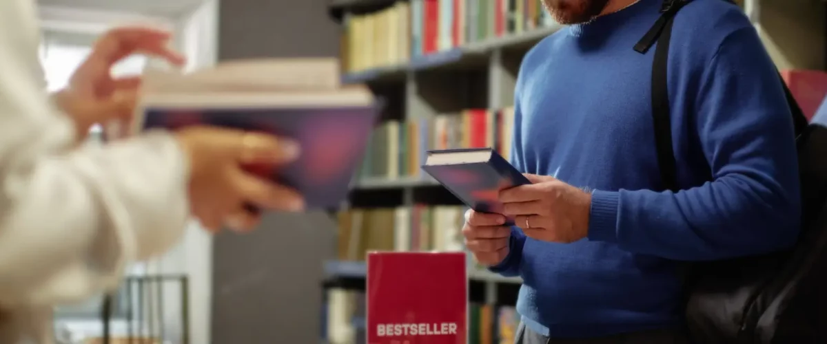young caucasian man browsing books in bookstore near bestseller display